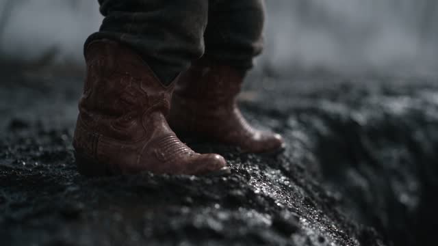 Les bottes du bébé qui freinent au bord du trou